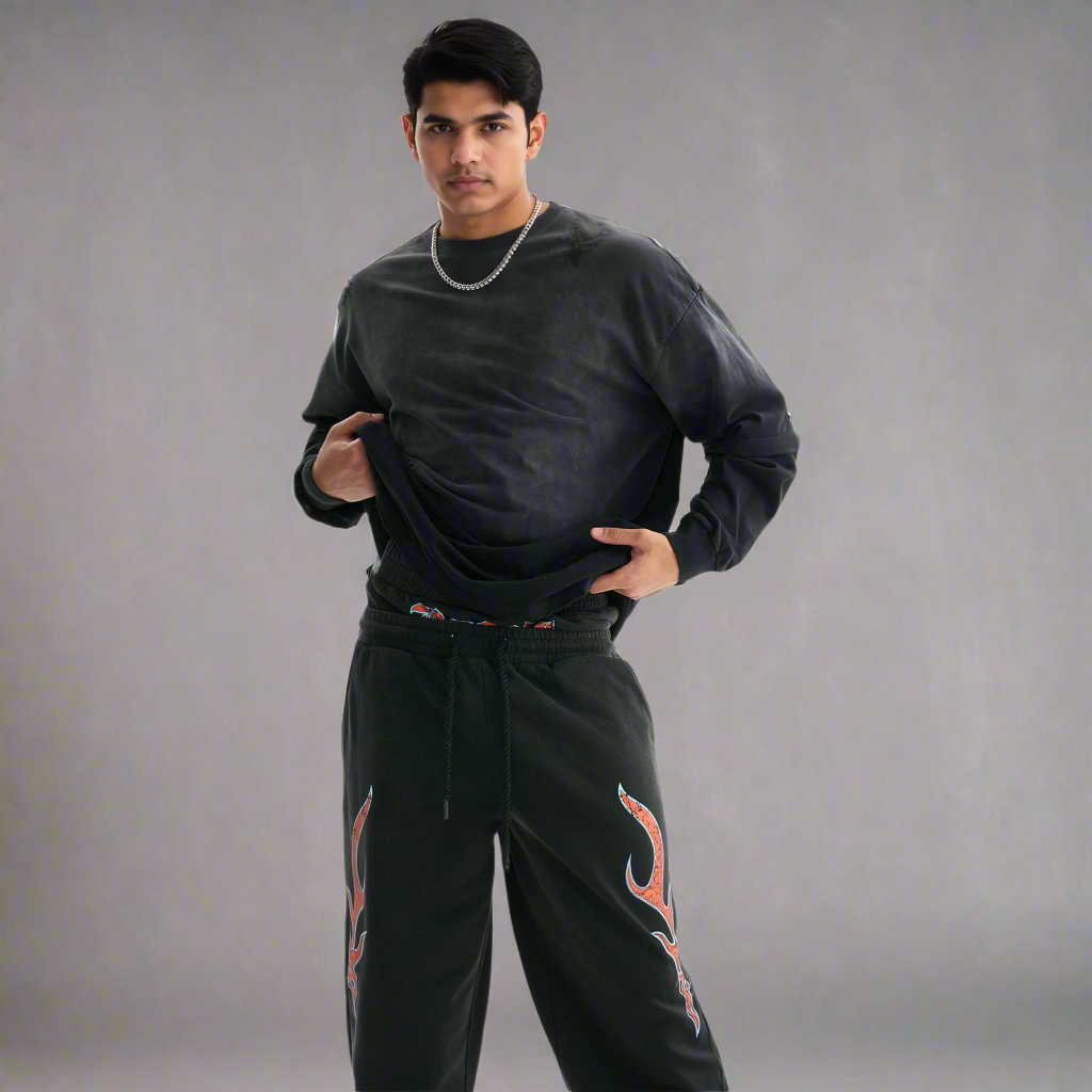 Man wearing a black sweatshirt and black pants with red designs on a white background