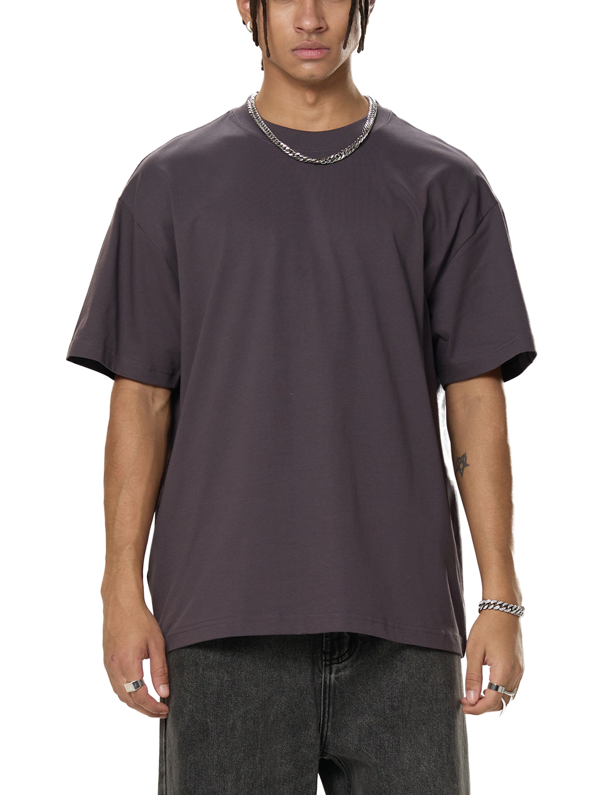Person wearing a plain dark gray t-shirt on a white background