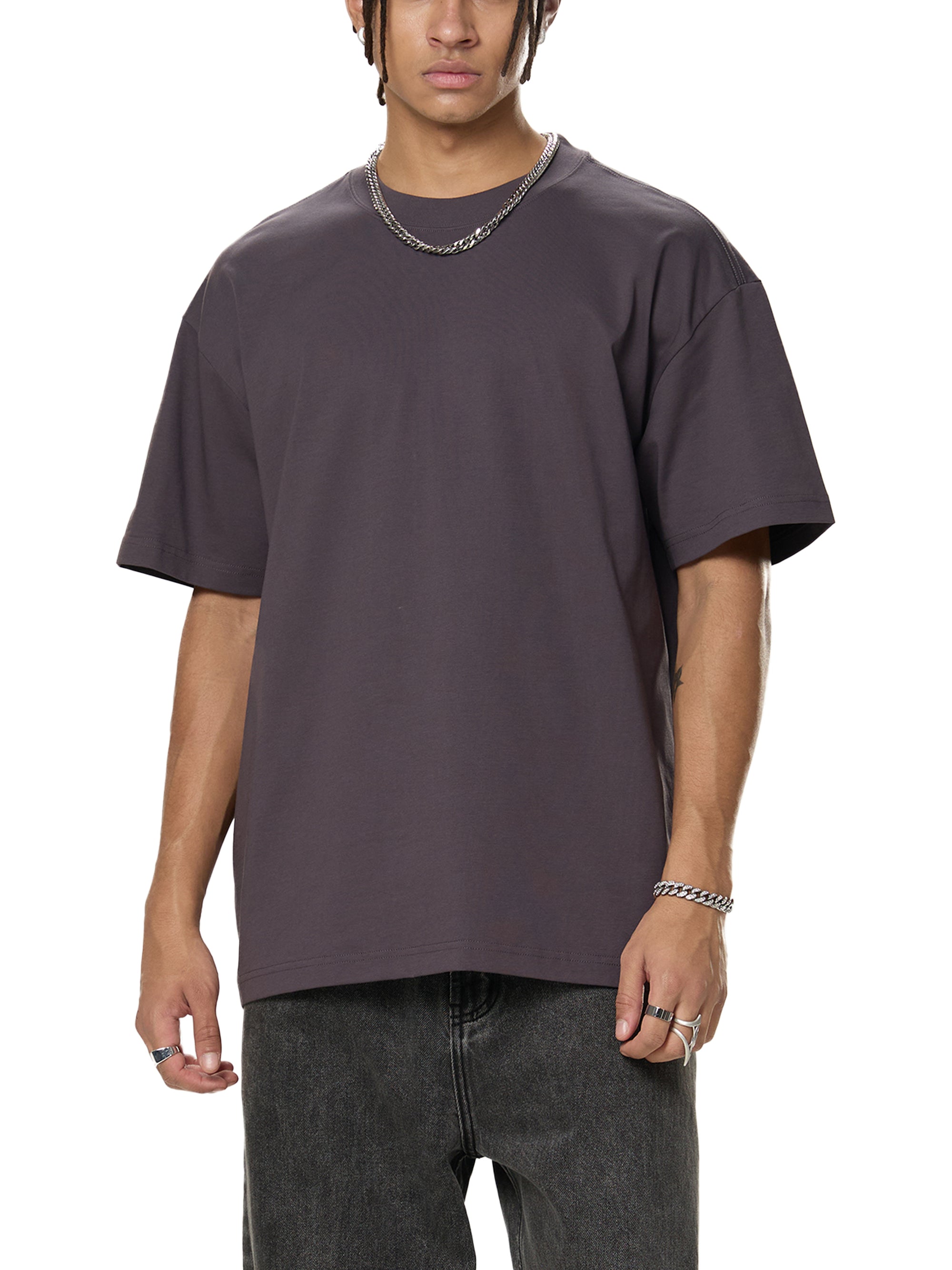 Person wearing a plain dark gray t-shirt on a white background