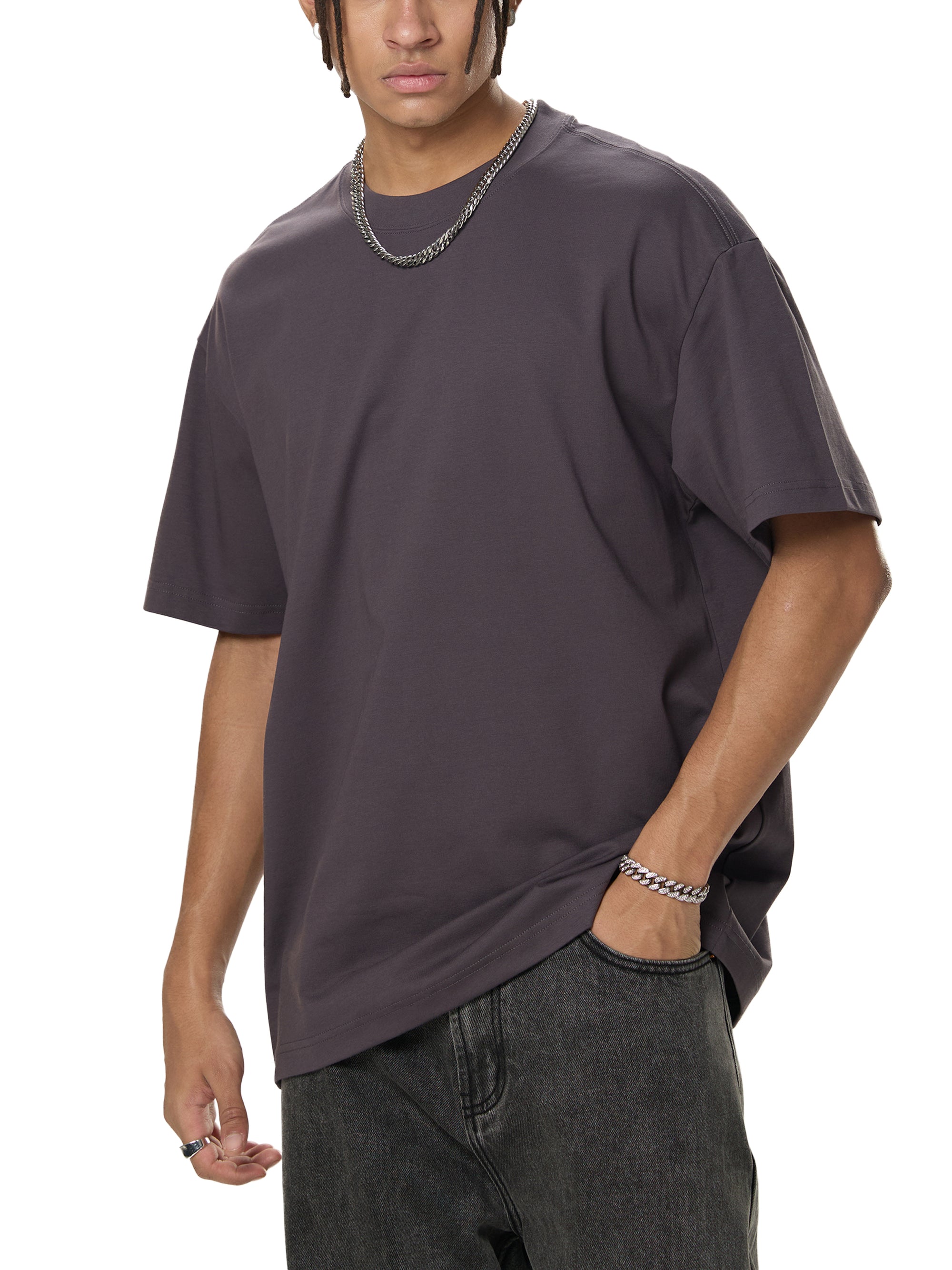 Person wearing a plain dark gray t-shirt and dark jeans on a white background