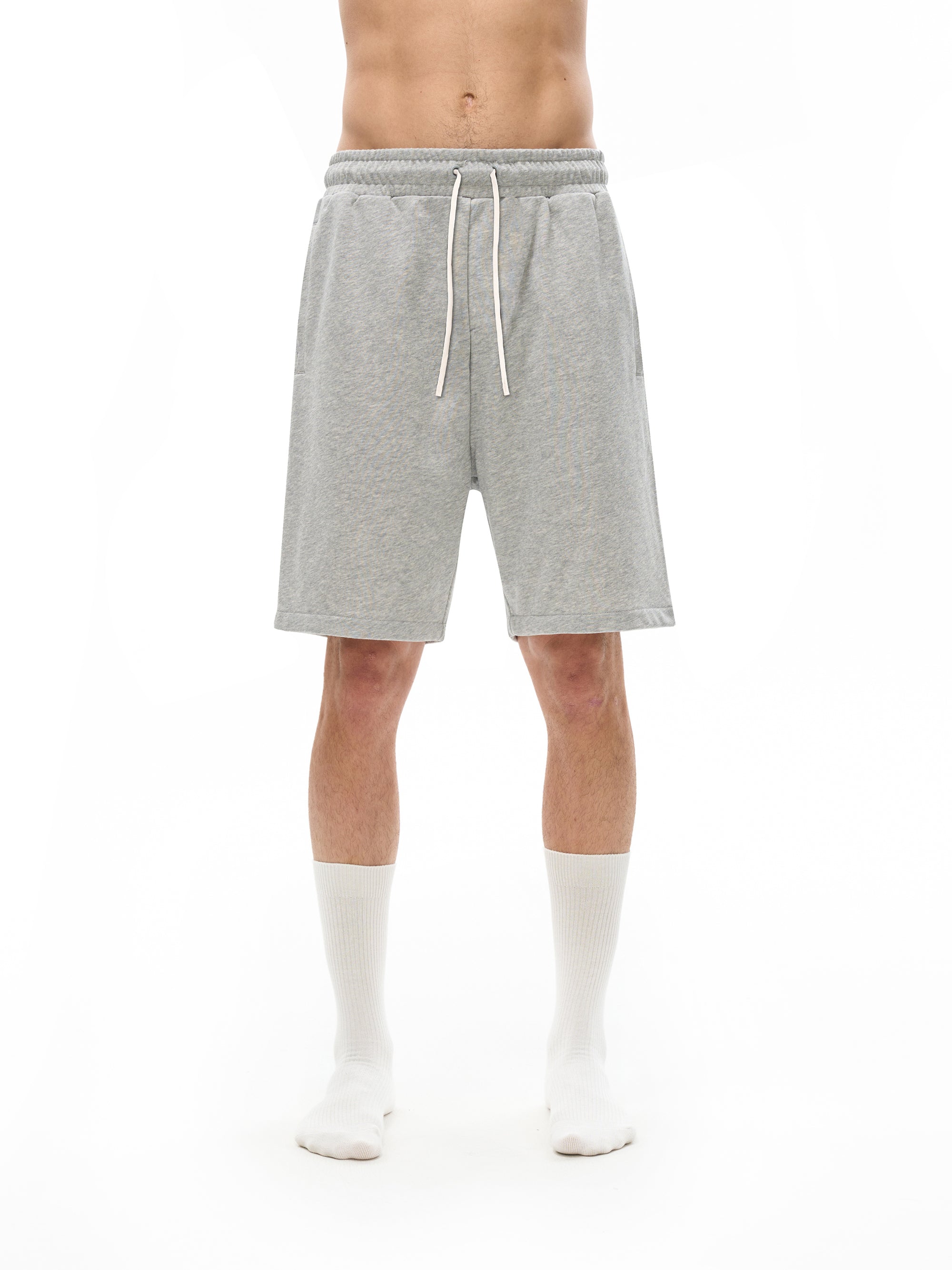 Person wearing gray shorts on a white background