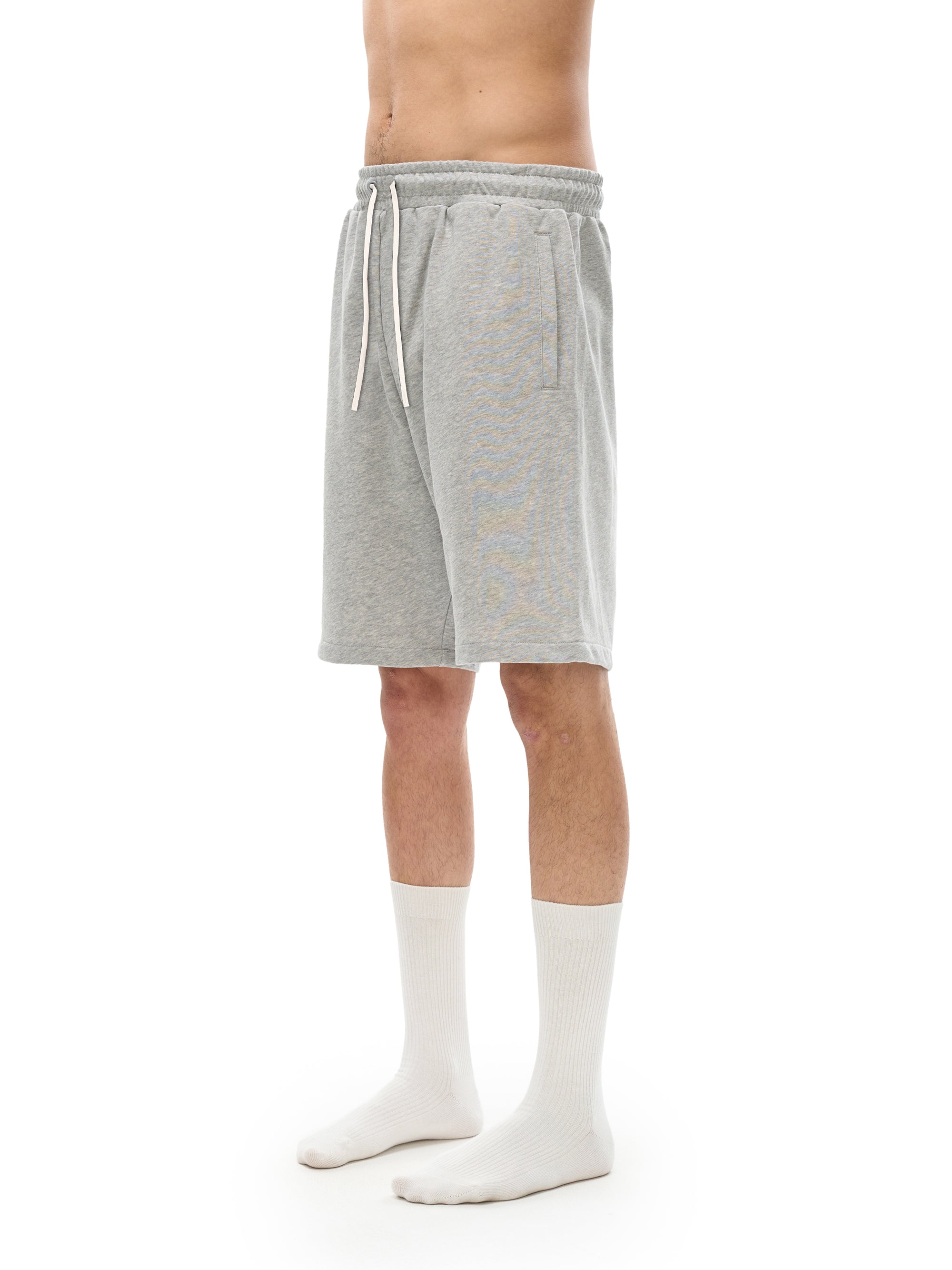 Person wearing gray shorts and white socks on a white background